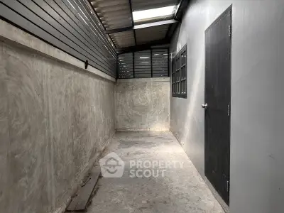 Spacious industrial-style storage room with concrete walls and skylight.