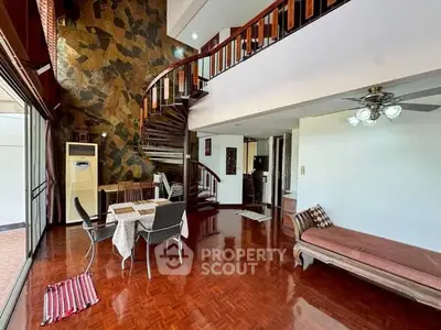 Spacious living room with elegant spiral staircase and wooden flooring