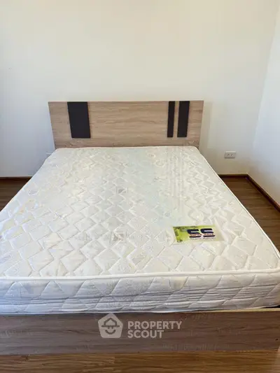 Modern bedroom with stylish wooden bed frame and comfortable mattress on polished hardwood floor.