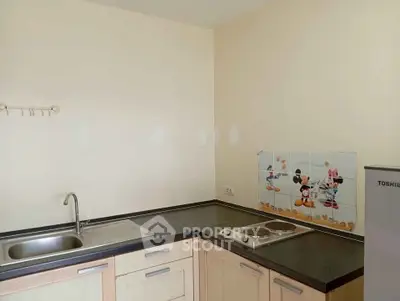 Charming kitchen with playful Mickey Mouse backsplash and modern appliances.