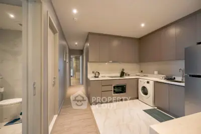 Modern kitchen with sleek cabinetry, integrated appliances, and stylish lighting in a contemporary apartment.