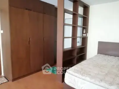 Spacious bedroom with built-in wardrobe and wooden shelving, perfect for modern living.