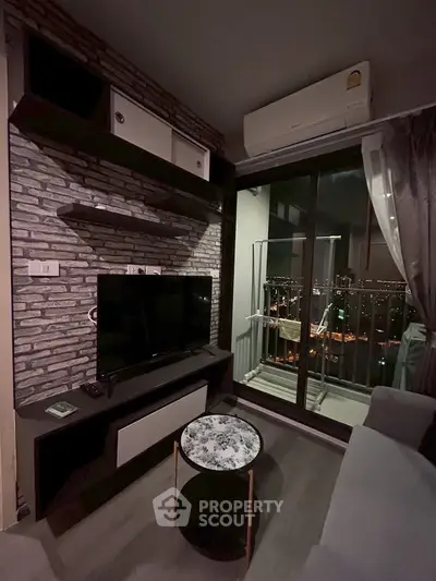 Modern living room with city view, featuring sleek TV setup and cozy balcony access.