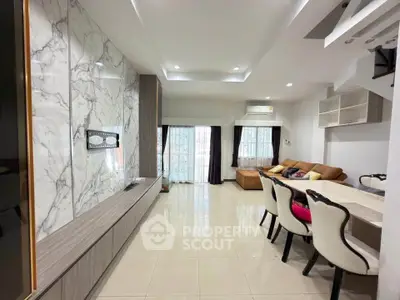 Spacious modern living room with elegant marble wall and cozy seating area.