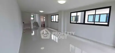 Spacious modern living room with large windows and glossy tiled floors