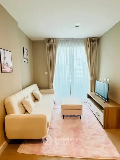 Cozy living room with modern decor, plush sofa, and natural light through large window.