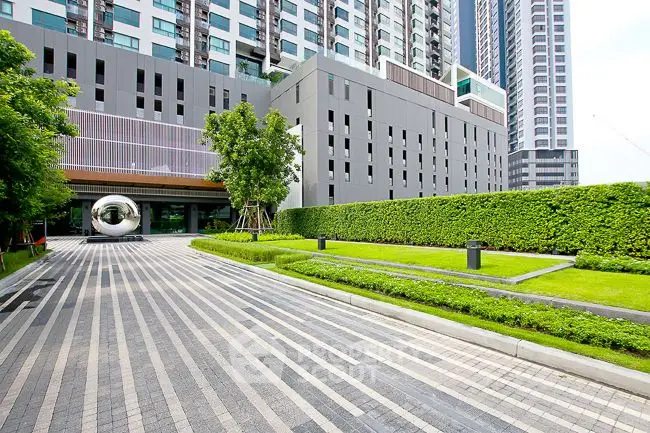 Modern urban building exterior with landscaped garden and driveway