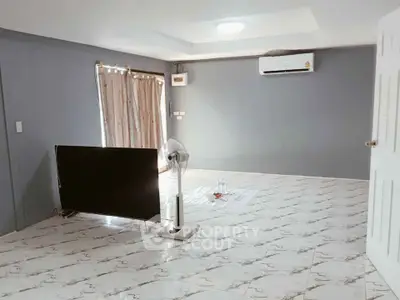 Spacious living room with modern air conditioning and elegant tiled flooring.