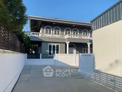 Elegant two-story house with arched windows and spacious driveway, perfect for modern family living.