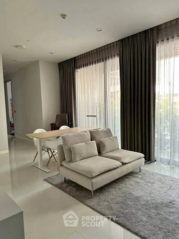 Modern living room with elegant decor and large windows for natural light.