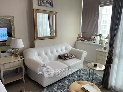 Chic living room with white sofa, elegant decor, and large window view.