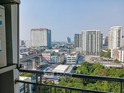 Stunning cityscape view from a high-rise balcony overlooking urban skyline and lush greenery.