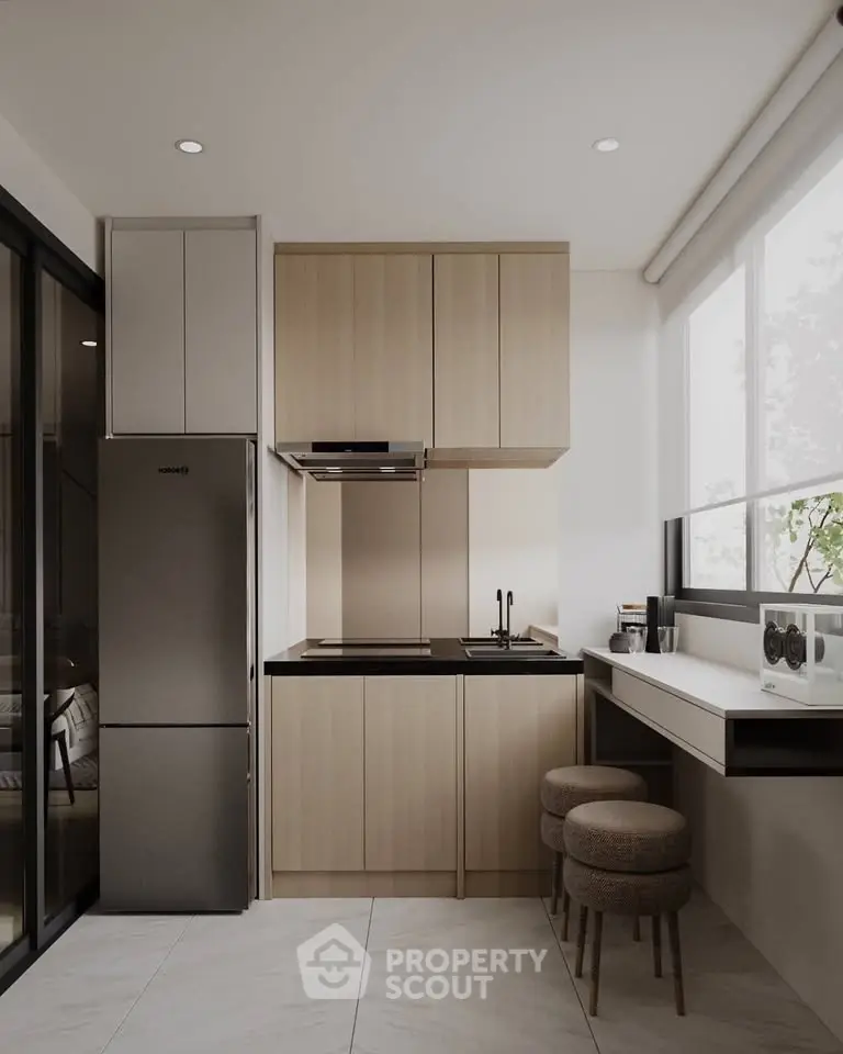Modern kitchen with sleek cabinetry, integrated appliances, and breakfast bar seating in a bright, airy space.