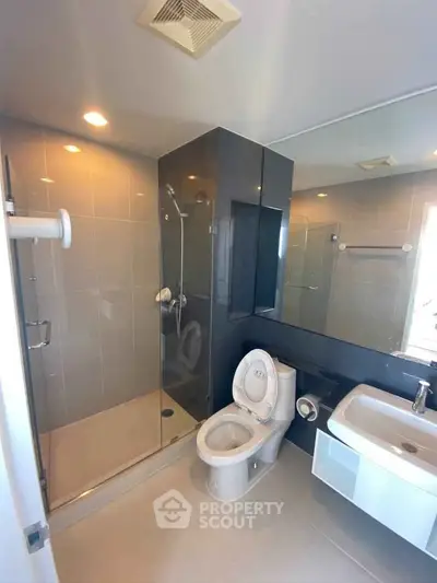 Modern bathroom with glass shower and sleek fixtures in a contemporary apartment.