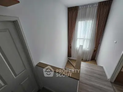 Inviting modern bedroom with ample natural light, featuring elegant wood flooring and tasteful neutral decor, perfect for a serene living experience.