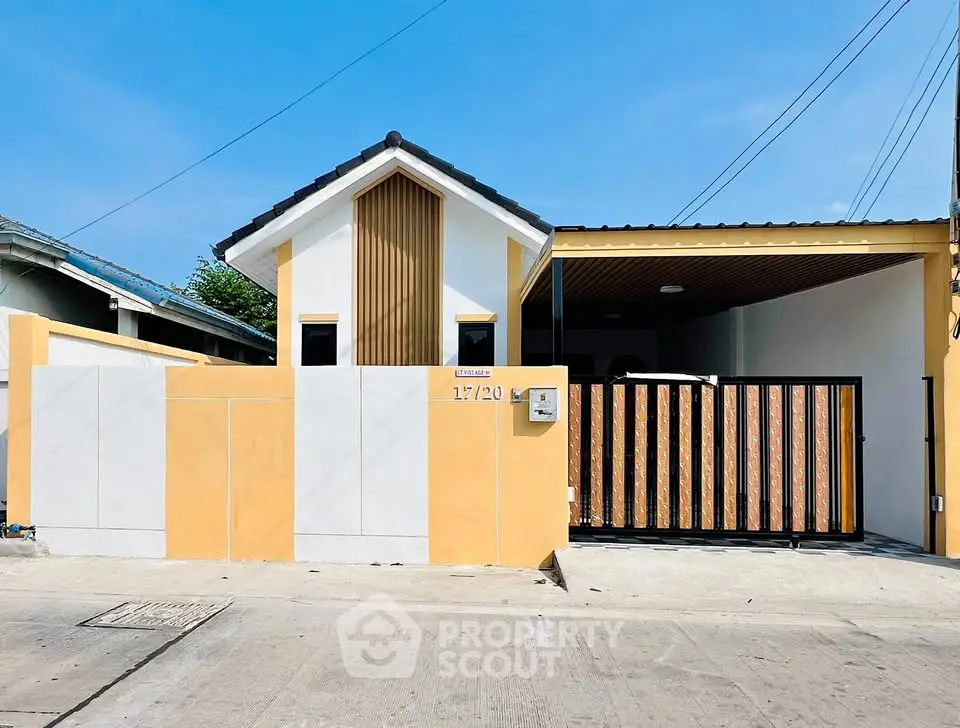 Modern single-story house with gated driveway and contemporary design.