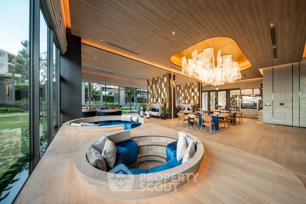 Luxurious modern living room with unique sunken seating and elegant chandelier, offering a stunning garden view.