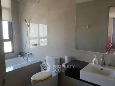 Modern bathroom with bathtub and sleek fixtures in a bright, airy space.