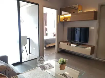 Modern living room with sleek TV unit and view into cozy bedroom