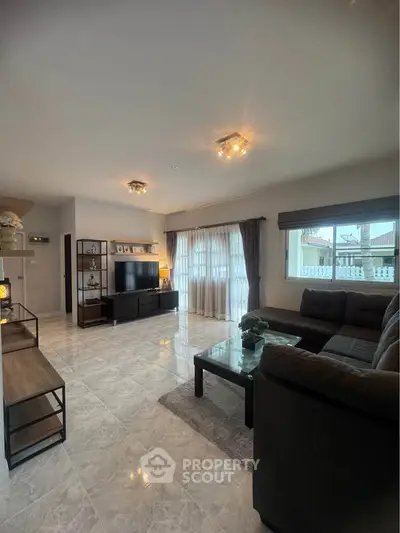 Spacious living room with modern decor and large windows for natural light.