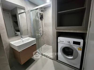 Modern bathroom with washing machine and glass shower enclosure