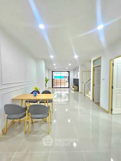 Spacious modern living room with dining area and sleek tile flooring.