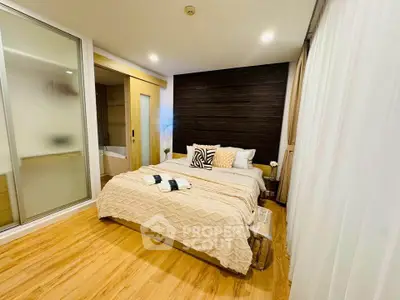 Modern bedroom with cozy decor and wooden flooring, featuring a stylish bed and ambient lighting.