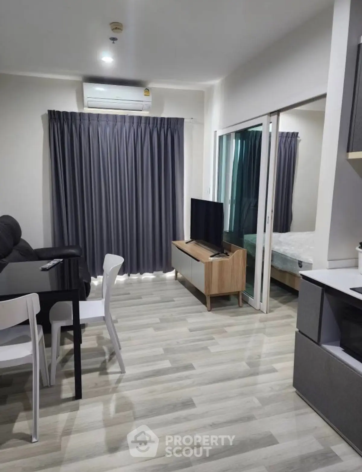 Modern living room with sleek furniture and open layout, featuring a cozy dining area and stylish decor.