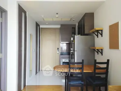 Modern kitchen with dining area, featuring sleek cabinets and stainless steel appliances.