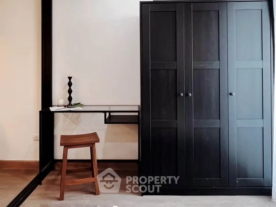 Modern study area with sleek black wardrobe and minimalist desk