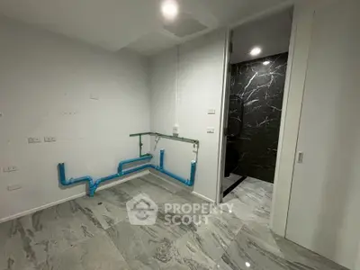 Unfinished bathroom with plumbing and marble tiles, ready for customization.