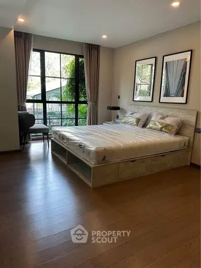 Spacious bedroom with large window and elegant decor in modern home