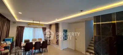 Spacious modern living room with elegant lighting and dining area, perfect for family gatherings.