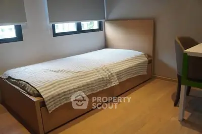 Cozy bedroom with single bed and natural light from windows
