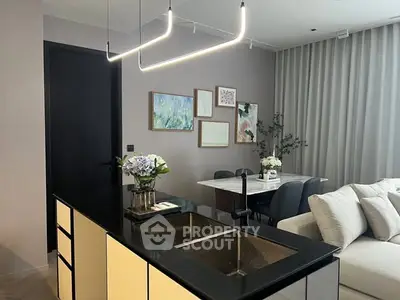 Modern open-layout kitchen with sleek black countertops and elegant dining area.