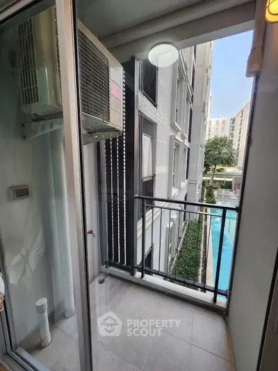 Compact balcony with pool view in modern apartment building