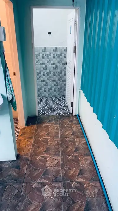 Charming tiled corridor leading to a modern bathroom with stylish wall tiles.