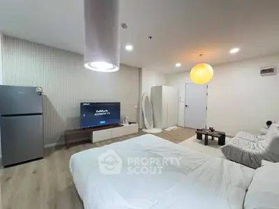 Modern studio apartment with cozy bed, TV, and stylish decor