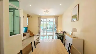 Bright and airy living room with modern decor and large windows leading to a balcony.