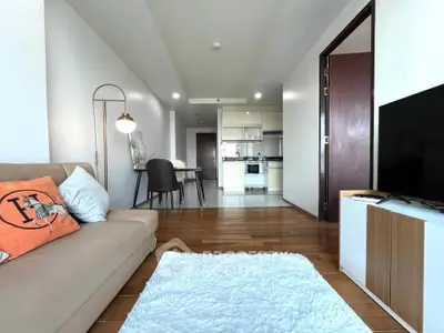 Modern open-plan living room with cozy seating and stylish kitchen area.