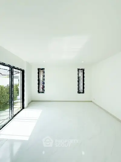 Spacious minimalist living room with large windows and marble flooring