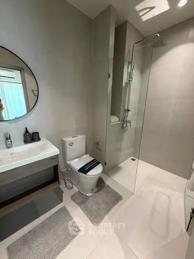 Modern bathroom with sleek design, featuring a glass shower and stylish fixtures.