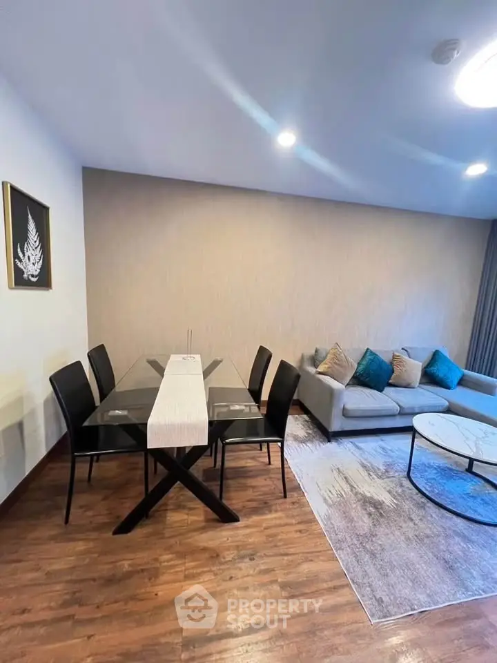 Modern living room with stylish dining area and cozy sofa, featuring elegant decor and wooden flooring.