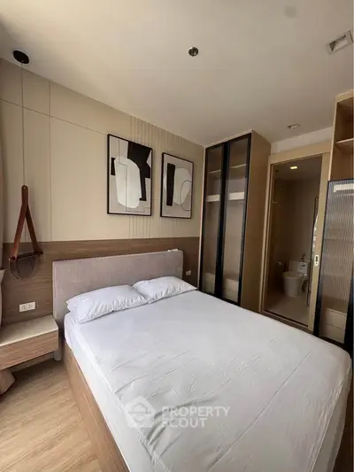 Modern bedroom with stylish decor and ensuite bathroom in a contemporary apartment.