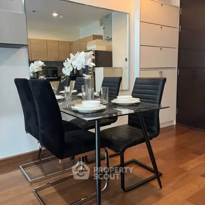 Modern dining area with sleek black chairs and elegant table setting in a stylish apartment.