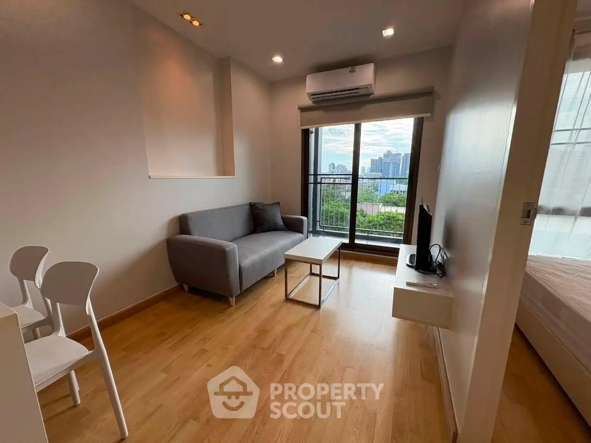 Modern living room with city view, featuring sleek furniture and natural light.