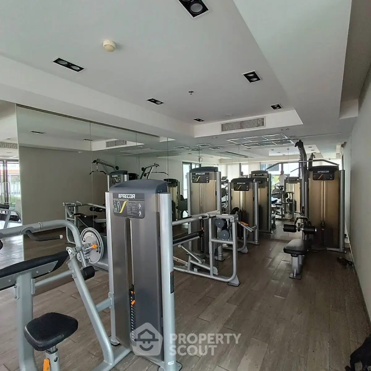 Modern gym with state-of-the-art fitness equipment and mirrored walls in a luxury building.