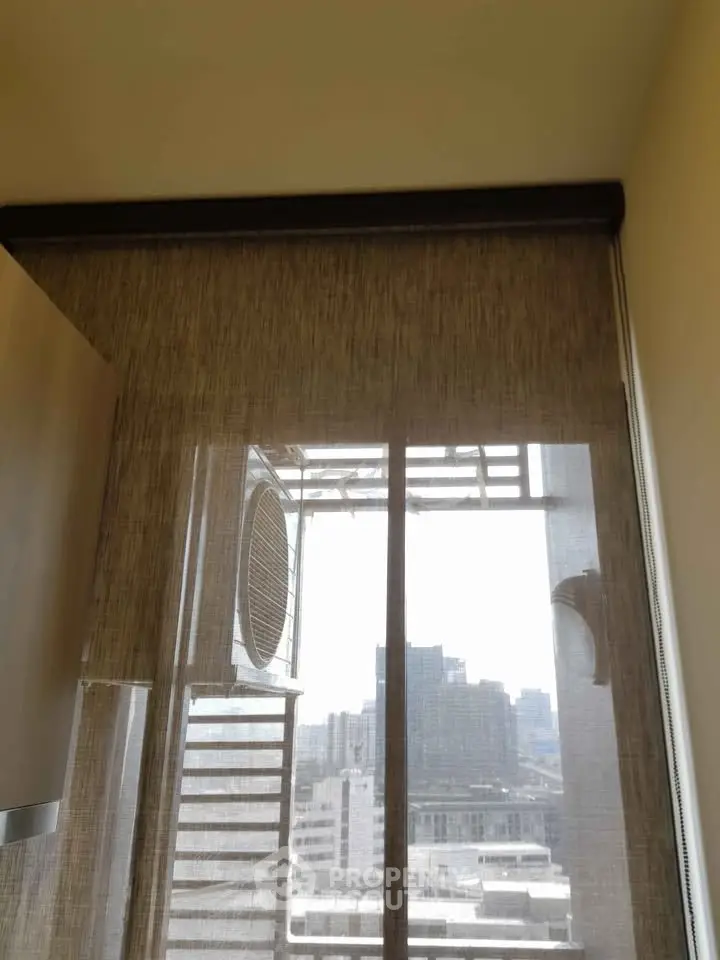 City view through modern window with stylish blinds in urban apartment.