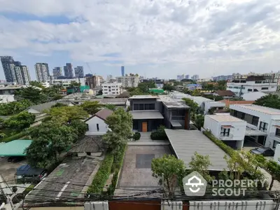 Stunning aerial view of modern residential neighborhood with lush greenery and city skyline backdrop.