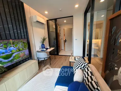 Modern living room with stylish decor and open layout, featuring a cozy seating area and a view into the bathroom.